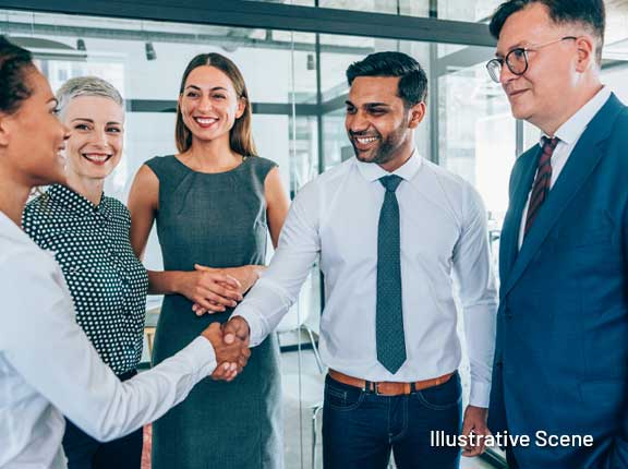 Employees shaking hands in work setting